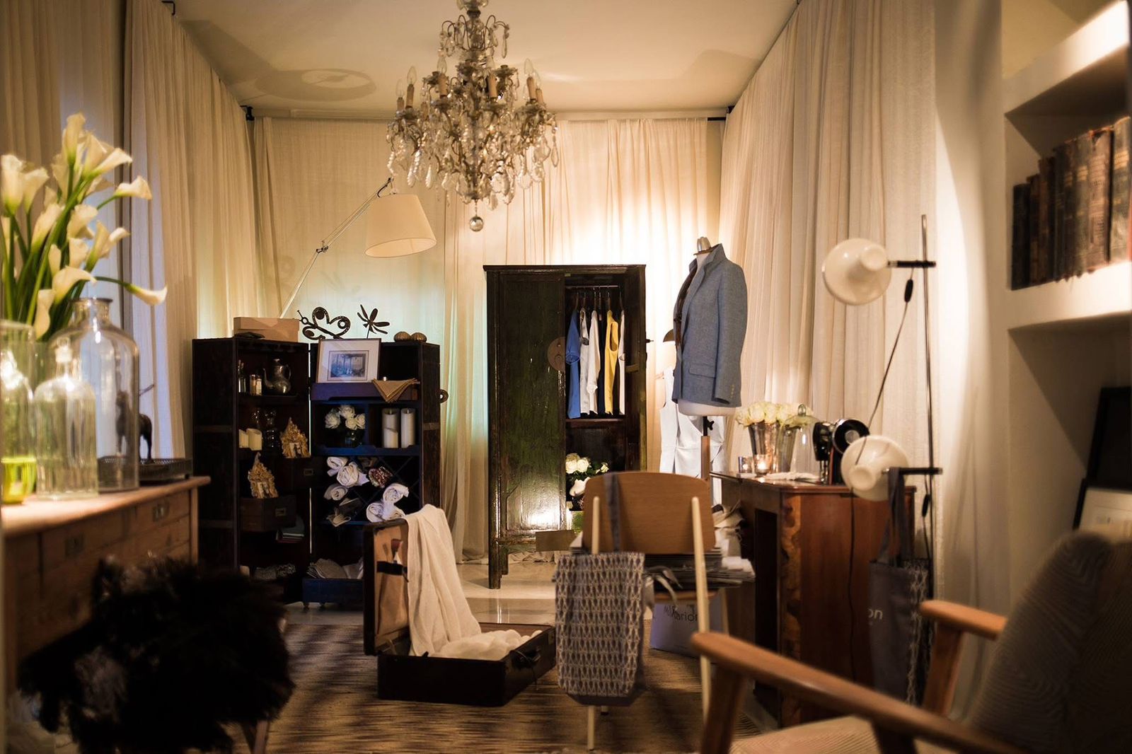 Ms Marion installation with tailored clothing, collected furniture and a crystal chandelier