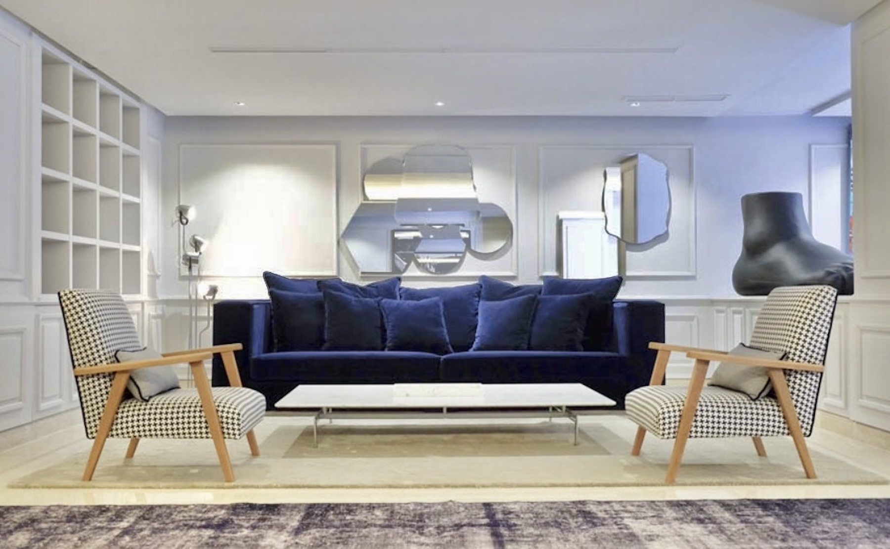 Living room with navy sofa and mirrored wall pieces
