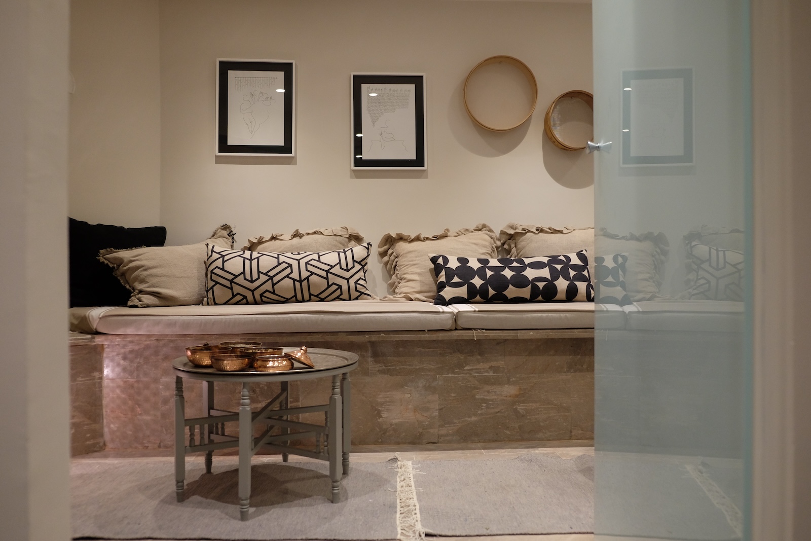 Rest area with built-in banquette, patterned cushions and copper bowls