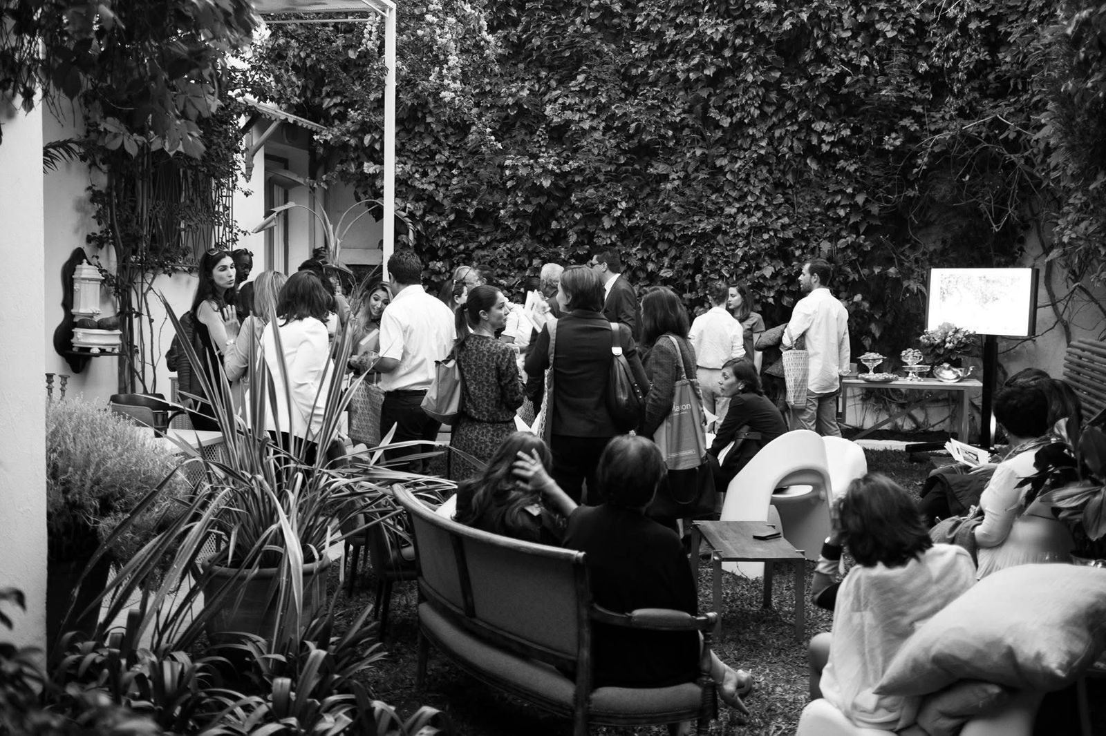 Black-and-white view of guests gathered in the garden at Ms Marion