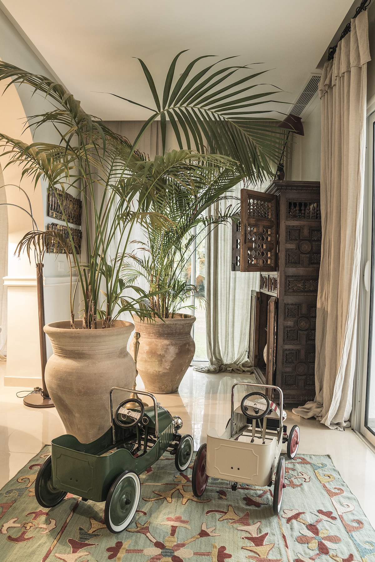 Indoor palms, antique cabinet and pedal cars