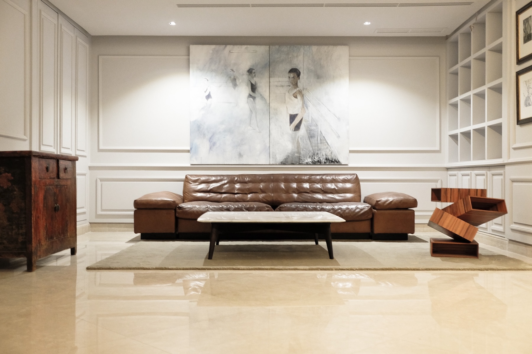 Salon with brown leather sofa and large painting