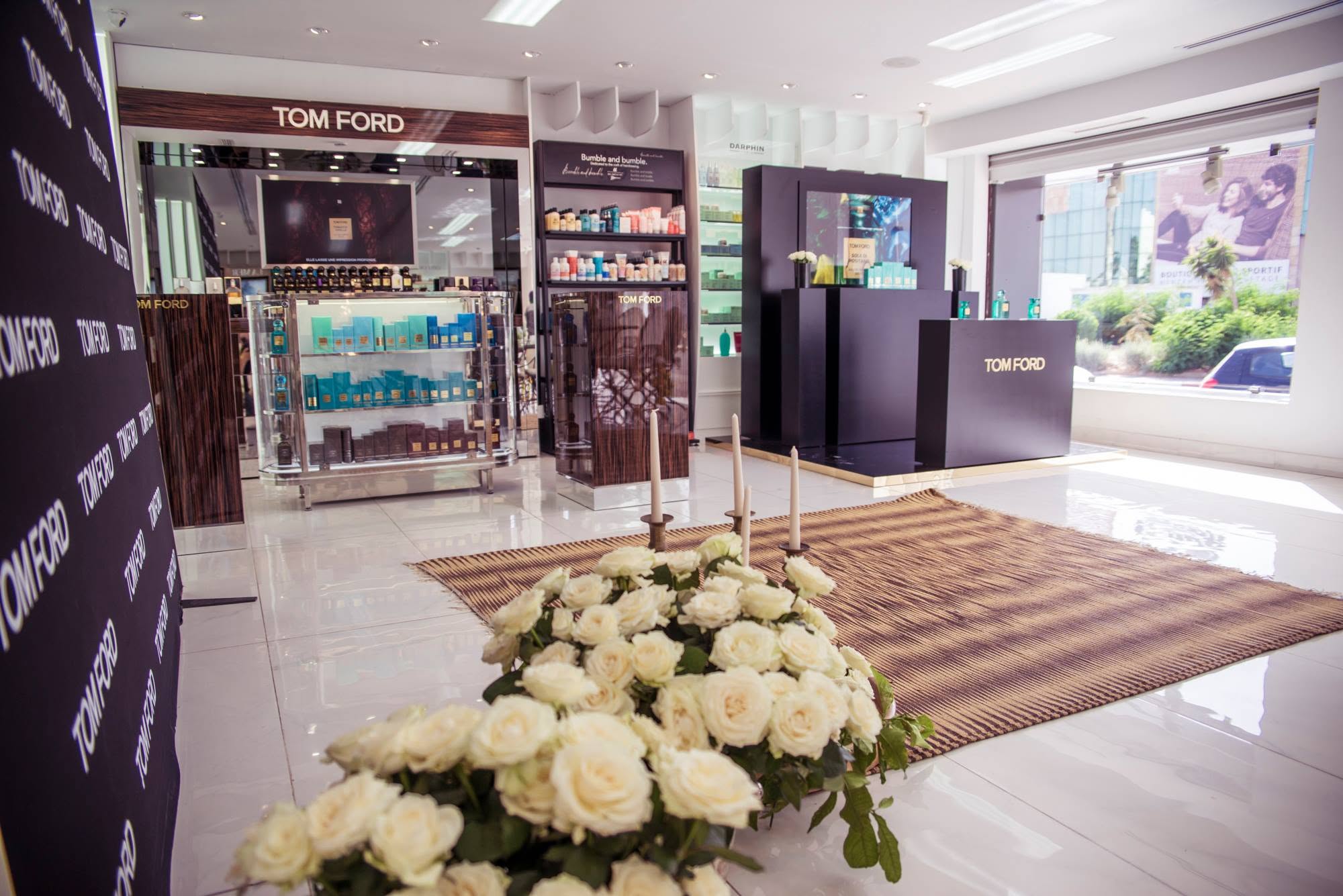 Tom Ford Sole Di Positano launch space with product displays and white roses