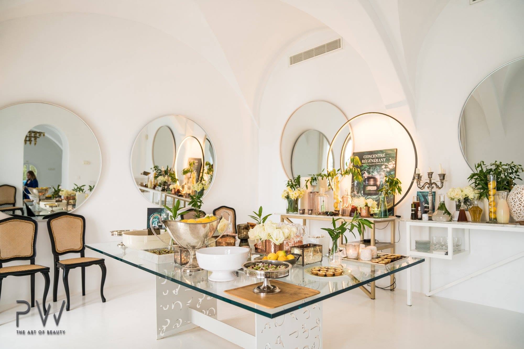Champagne glasses, white roses and copper serving pieces at the La Mer event