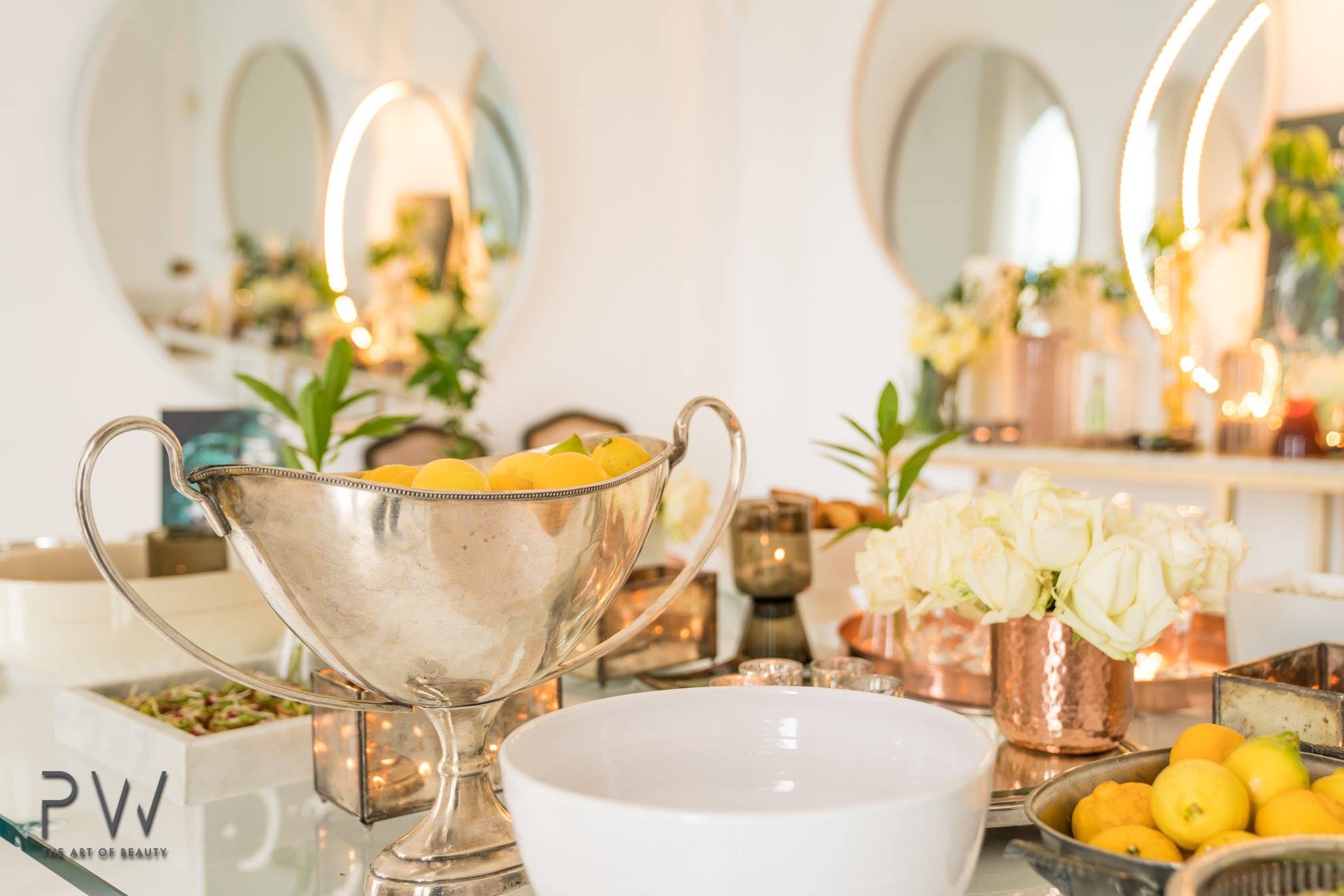 Silver bowl of lemons with white roses and copper details at the La Mer event