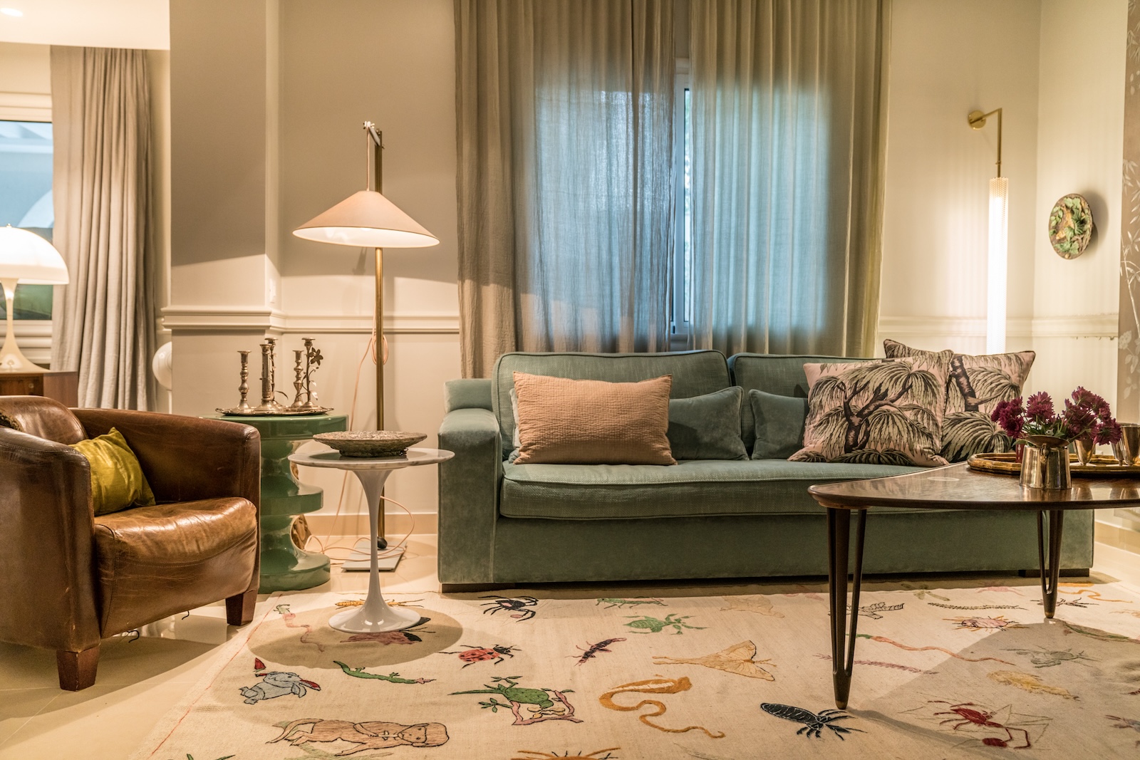 Living room with green sofa and illustrated rug