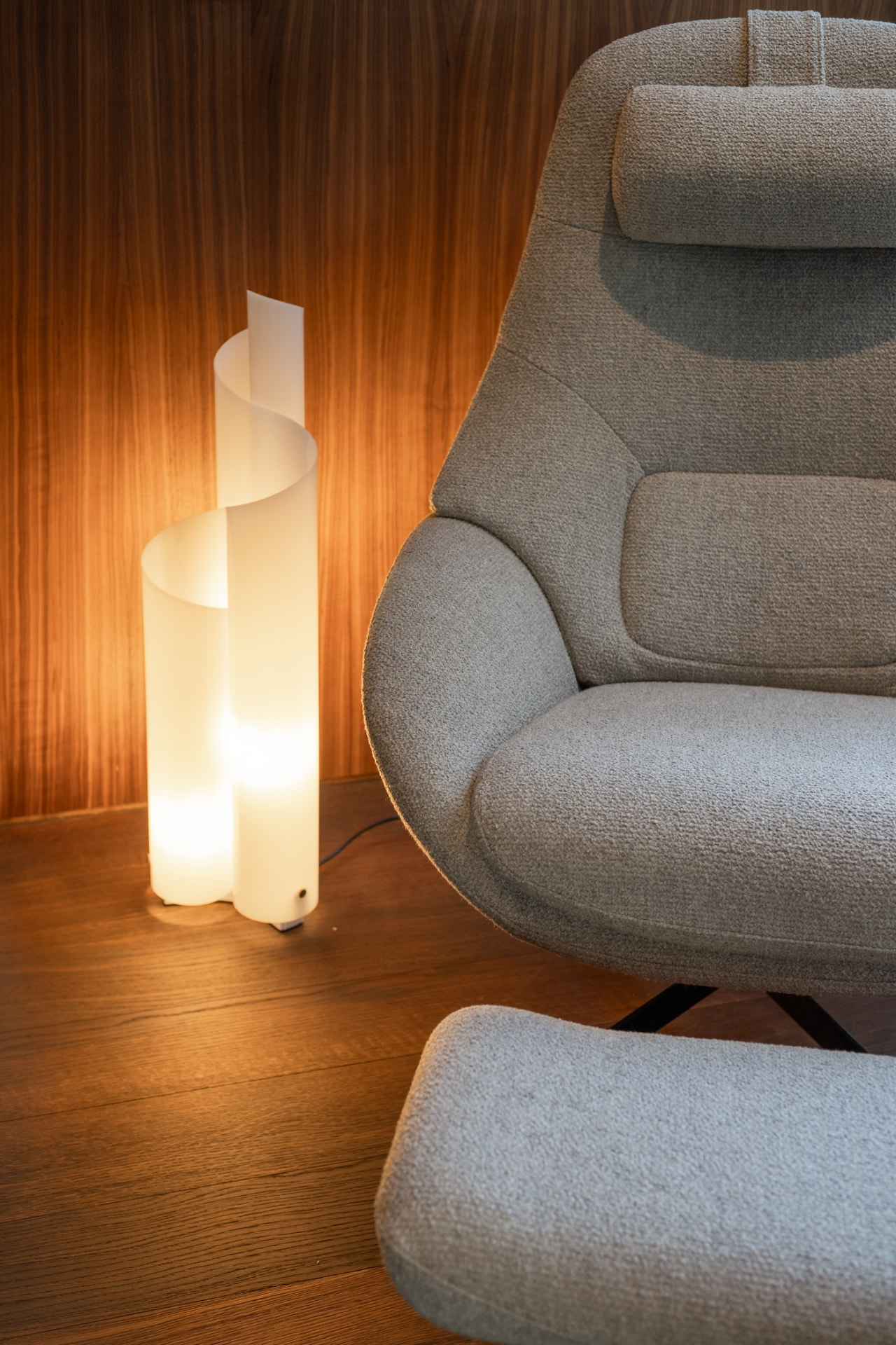 Armchair and floor lamp against walnut panelling