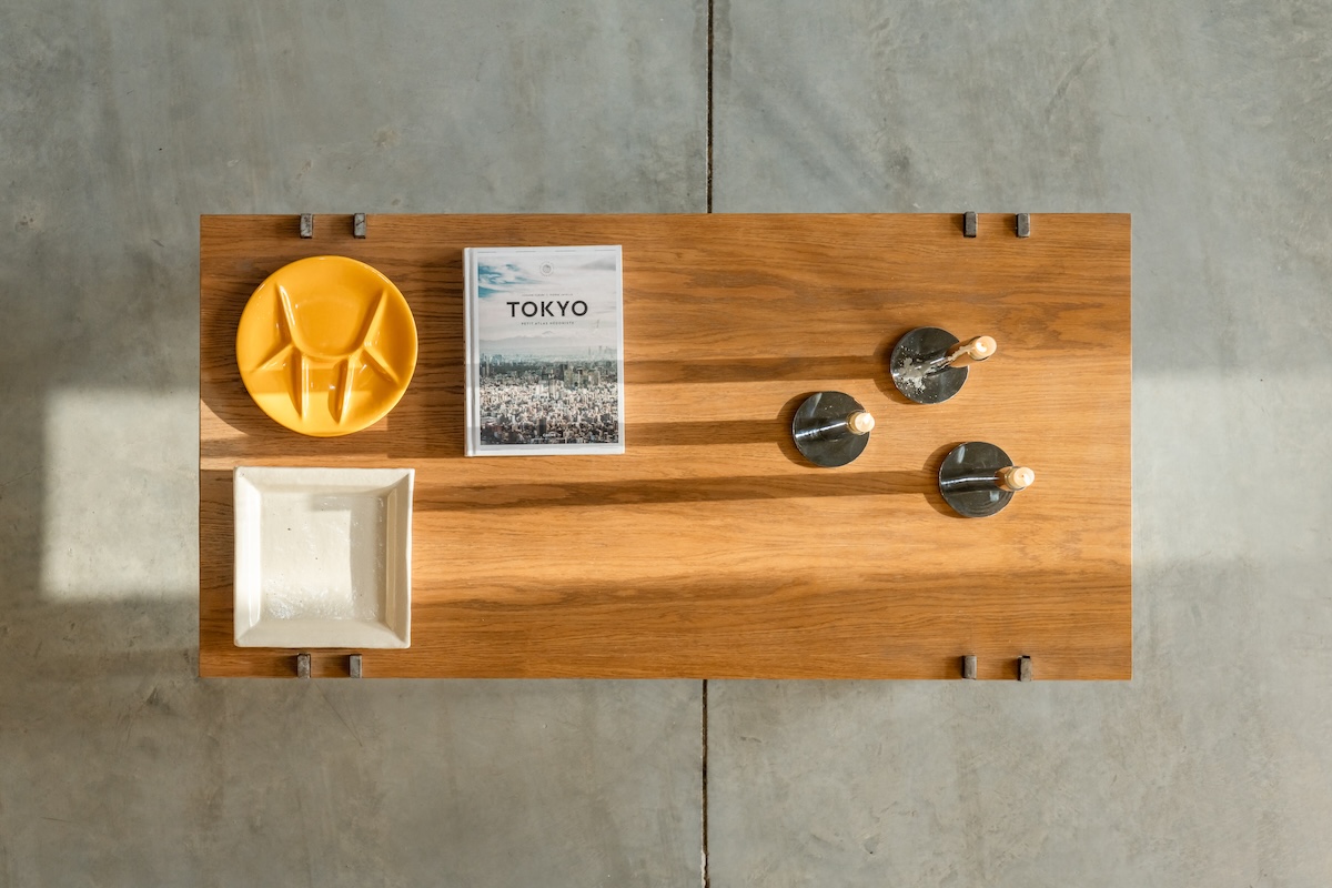 Wooden table arranged with ceramics, candleholders and a Tokyo book