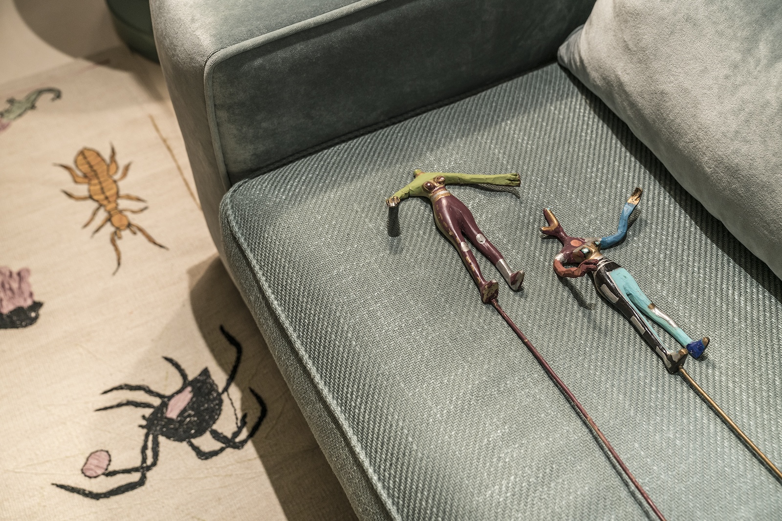 Decorative figures resting on a green sofa