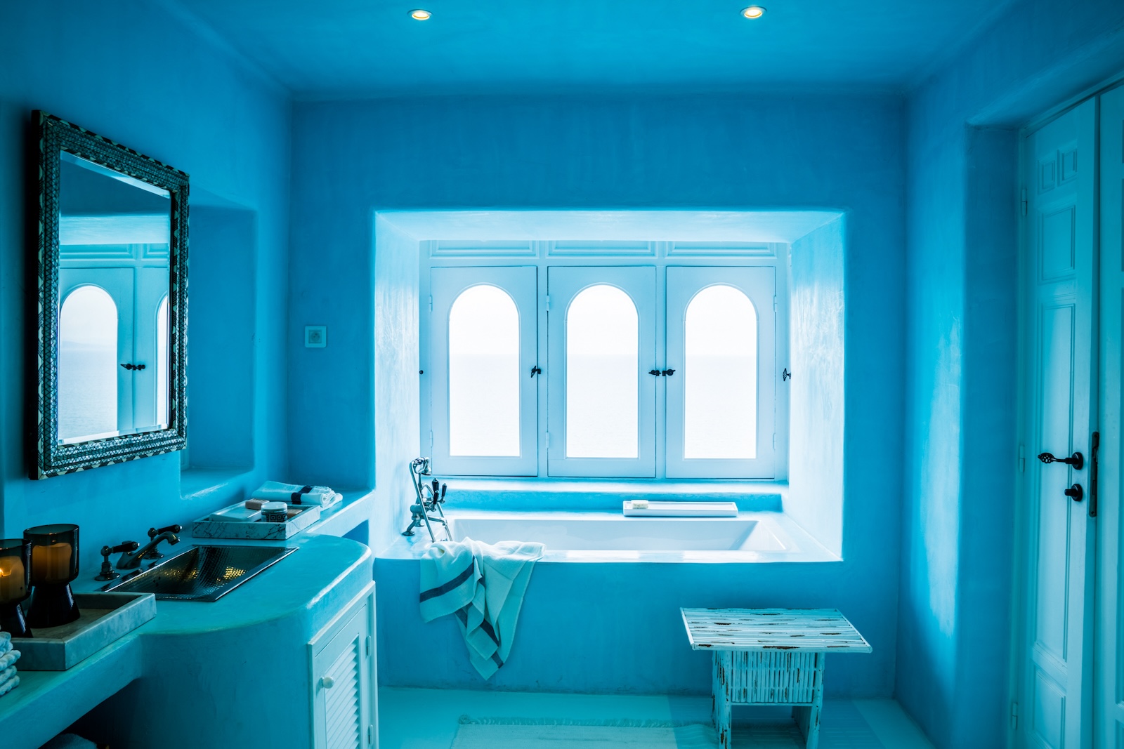 Blue bathroom with a white bathtub and built-in vanity