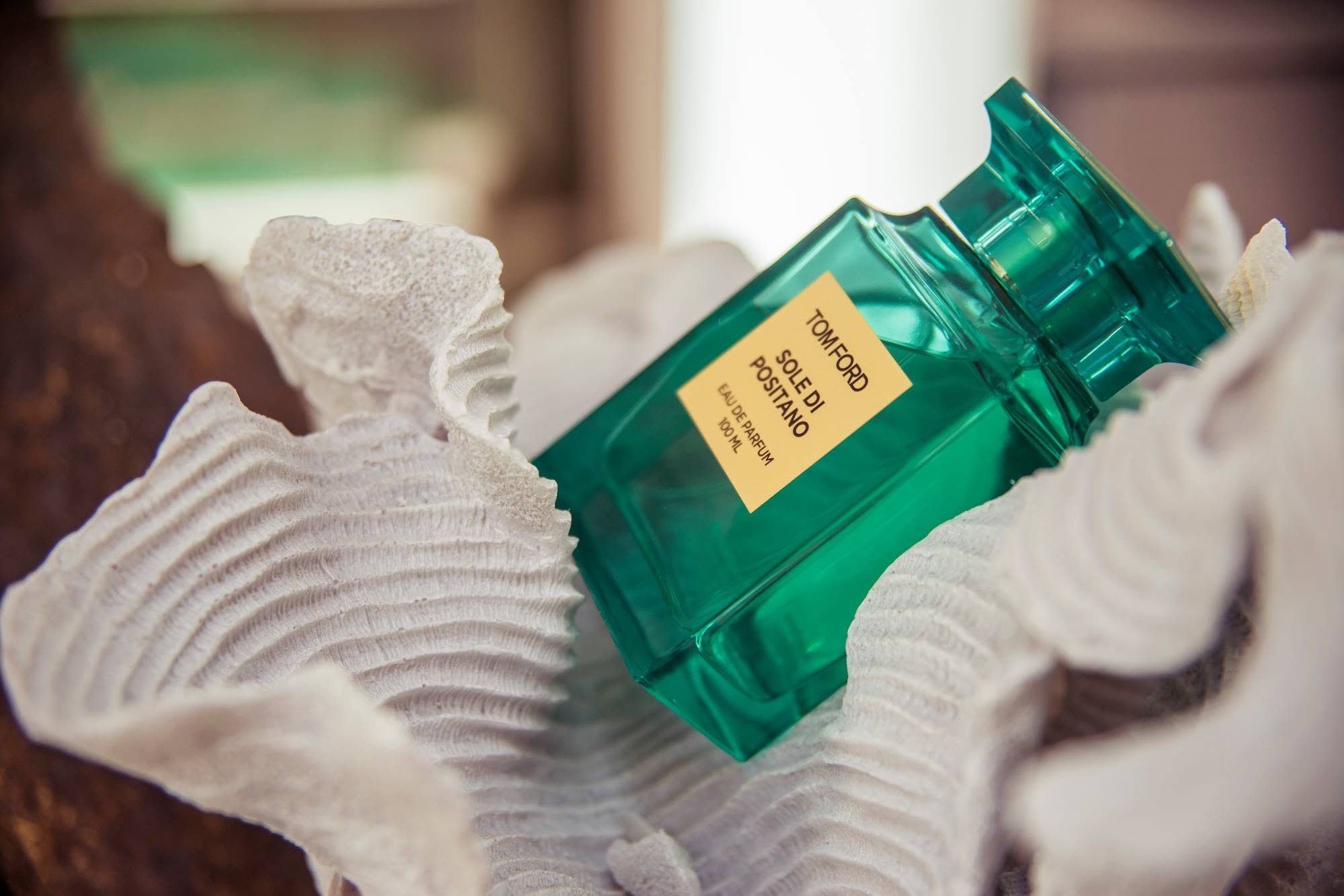 Tom Ford Sole Di Positano fragrance displayed among white sculptural shells