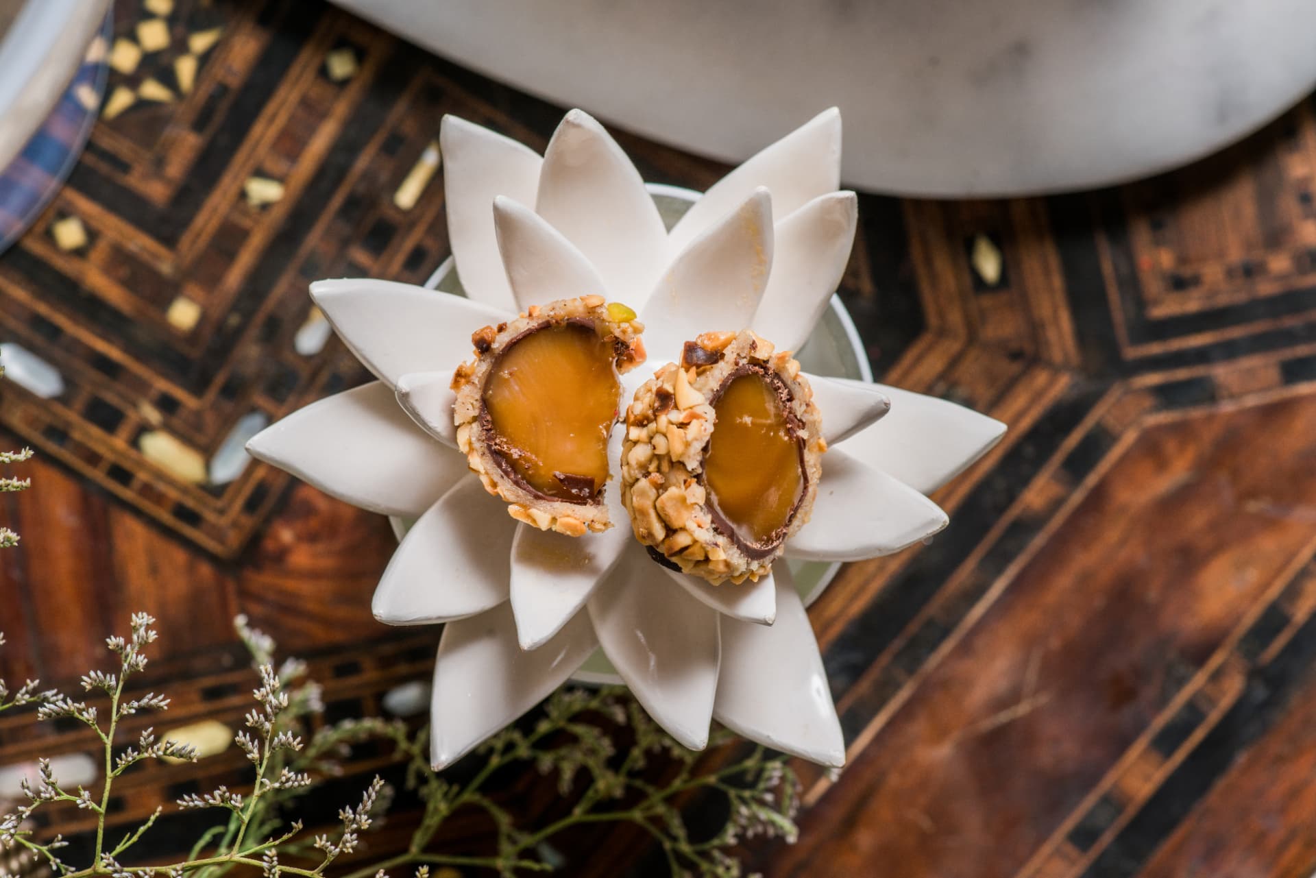 Chocolate and caramel sweets resting on a white porcelain lotus flower
