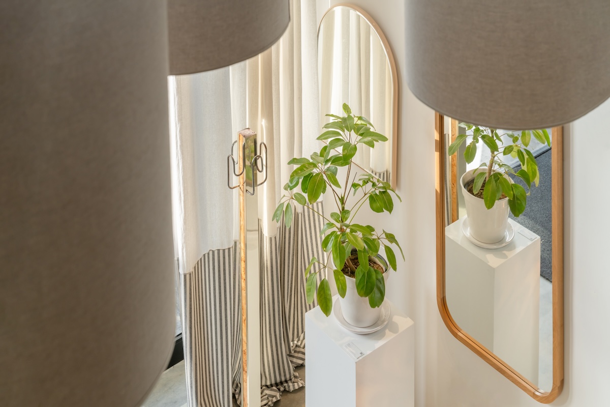 Plants and rounded mirrors framed by sculptural fabric forms