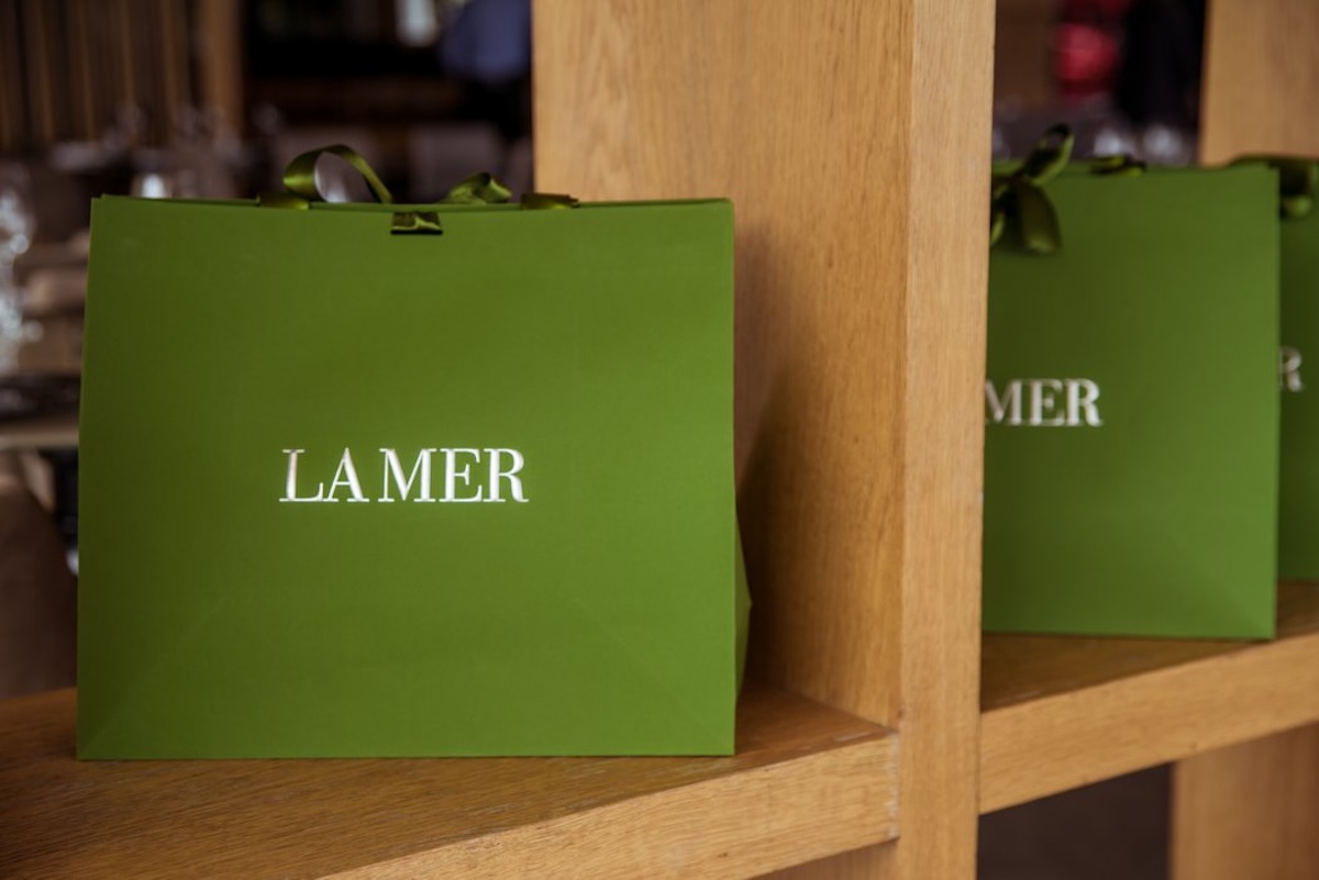 Green La Mer gift bags displayed on wooden shelving