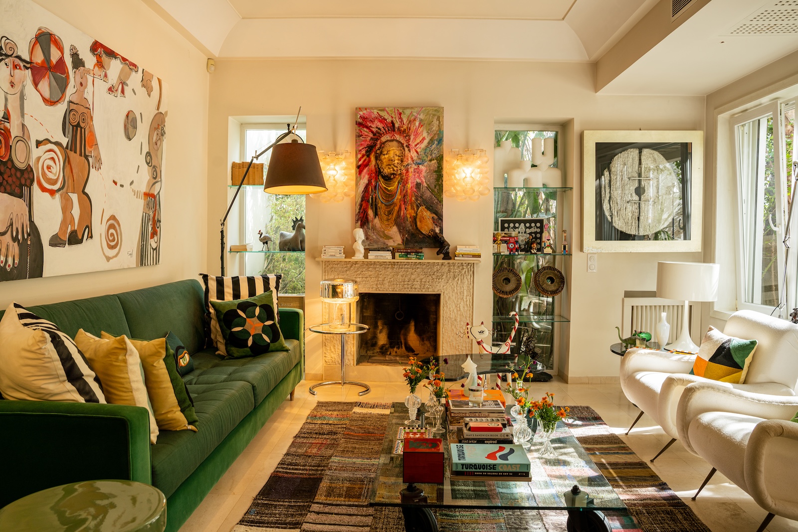Living room with green sofa, fireplace and artworks
