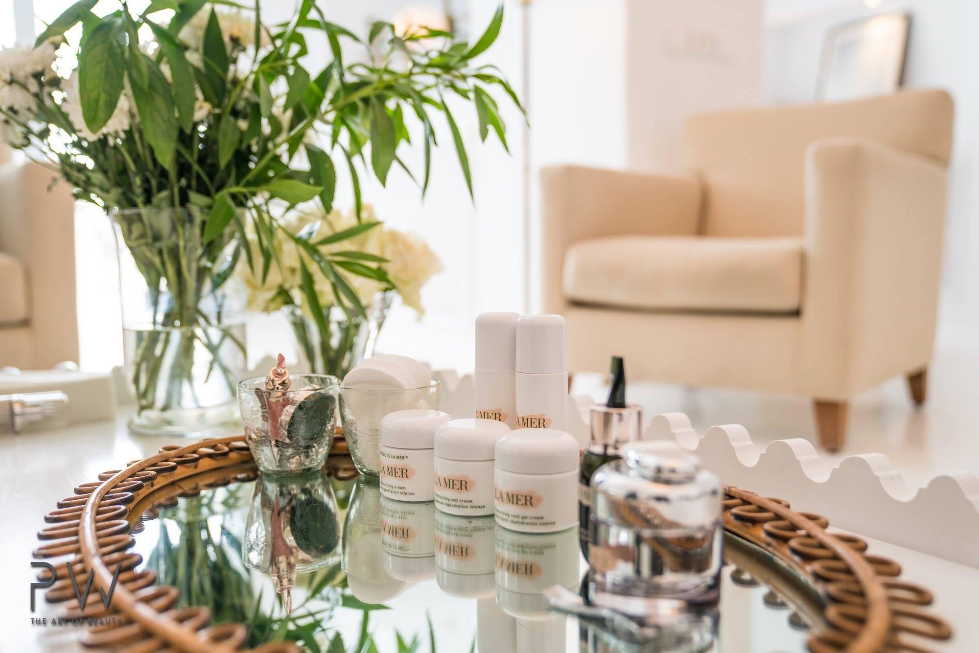 La Mer skincare products arranged on a mirrored tray with flowers